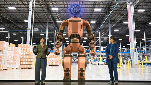Boston Dynamics Atlas humanoid robot standing in Hyundai Motor Group factory environment, representing the company's $26 billion physical AI and robotics investment strategy